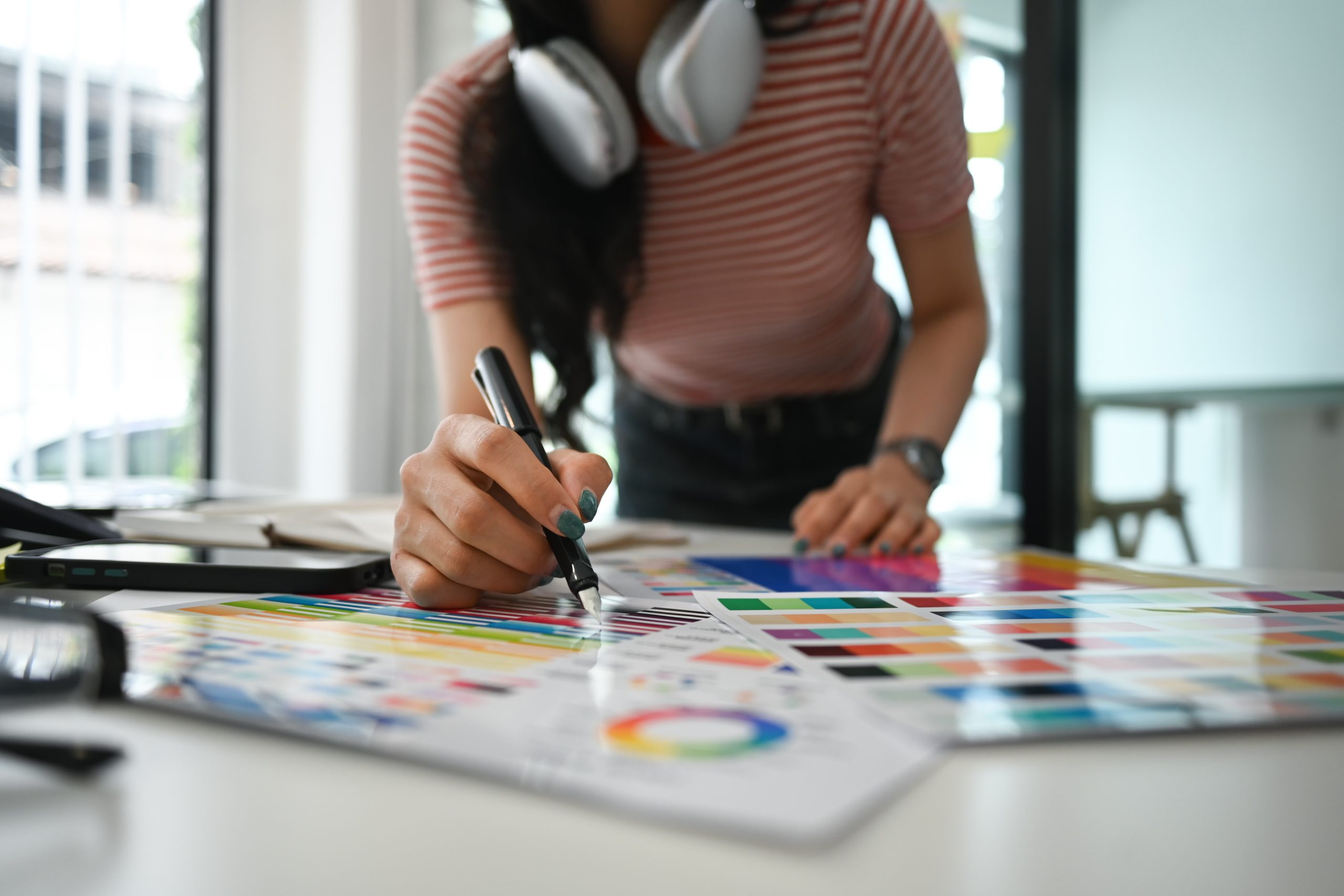 Closeup creative woman select color on color swatch, Graphic design workspace..