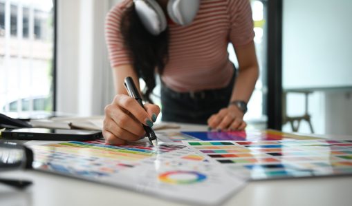 Closeup creative woman select color on color swatch, Graphic design workspace. Closeup creative woman select color on color swatch, Graphic design workspace..